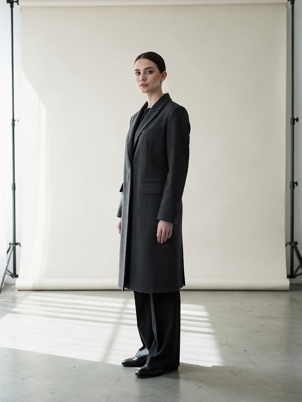 Model showcasing high-end minimalist women outerwear and tailored dress